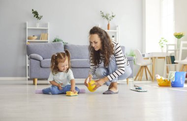 İyi eğitimsel hobiler, çocuk, anne ve küçük kızında yaratıcılık becerileri geliştirme, rahat oturma odasında, anne kızına çalışmayı öğretiyor, evi temiz ve düzenli tutmayı öğreniyor. 