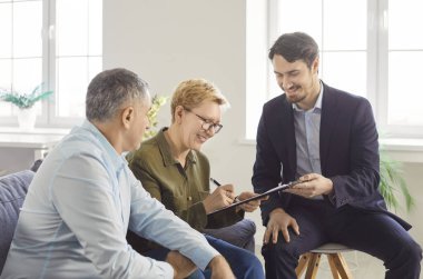 Belgeleri imzalamak, emlakçı, komisyoncu kıdemli satıcıları temsil ediyor, alıcı sözleşmesi, müşteriler proje planına bakarak toplantıyı denetliyor, gösteriyor, planlıyor, mühendis, mimar ile görüşüyor.