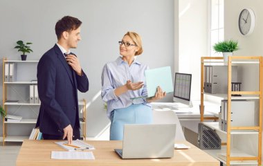 Ofiste birlikte çalışan iş arkadaşları, toplantı sırasında muhasebe için dizüstü bilgisayar kullanıyorlar. İşbirlikleri ve konuşmaları verimli iş yönetimi üzerinde yoğunlaşıyor.