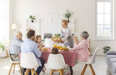 Hafta sonu evde yemekle birlikte aile yemeği masasında toplanıyor, birlikteliği ve mutluluğu kutluyorlar. Aile eğlencesi, neşe ve beraberliğin sıcaklığı şenlikli bir yemeğin etrafında..