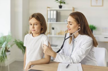 Akciğerleri kontrol eden çocuk doktoru, klinikteki çocuk hastasının kalbi, kadın doktor, steteskop tutan hemşire hastanede düzenli çocuk kontrolü sırasında küçük çocuğu muayene eden hemşire, çocuk sağlığı hizmetleri...