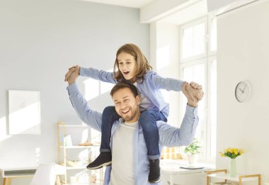 İki neslin eğlenceli ailesi, iki yetişkin babası, çocuk oğlu birlikte uçak oyunu oynuyorlar, babalarını kutluyorlar bayram eğlenceleri, omuzlarında sevimli bir çocuk taşıyorlar.