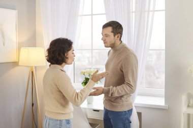 Genç, üzgün bir çift, evde durmuş kavga ediyorlar. Mutsuz karı koca oturma odasında kavga ediyor. Evlilik sorunları, ilişki ve boşanma kavramı.