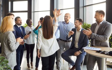 Arkadaş canlısı, mutlu, çeşitli çalışanlar büyük iş başarıları, iyi iş sonuçları veya iş promosyonları ile tebrik ediyorlar, iş adamları dostlarını alkışlıyorlar, modern ofiste tezahürat yapıyorlar, terfi alıyorlar.