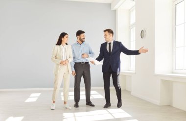 Emlakçı ya da emlakçı bir emlak anlaşmasını sonuçlandırmadan önce birkaç müşteriye bir ev ya da daire gösteriyor, emlak danışmanlığı ve işlemlerindeki temsilci rolünü vurguluyor.