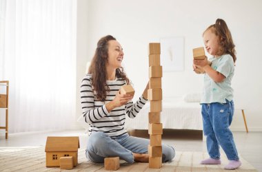 Anne ve kızı tahta oyuncaklarla oynamayı, evde birlikte gülmeyi seviyorlar. Bu eğlenceli aile eğlencesi, rahatlamış bir ortamda neşe, bağ ve beraberliği yakalar..