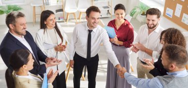 İş adamlarının üst düzey görüşü, erkek meslektaşlarıyla çember oluşturup el sıkışmalarıdır. Bir grup profesyonel iş arkadaşını alkışlıyor, başarıyı kutluyor, destek ve onay veriyor. Pankart.