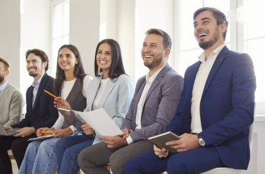 İş adamlarından oluşan bir ekip, takım çalışmasının keyfini çıkarırken ofis toplantılarına ya da konferanslara katılarak gülüyor. Sunum işbirliğini ve olumlu bir atmosferi teşvik eder.