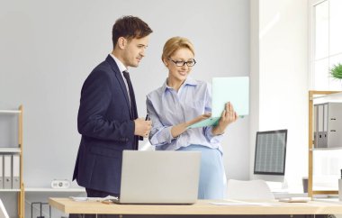 İş arkadaşları bir dizüstü bilgisayarla modern ofiste işbirliği yapıyor ve birlikte çalışıyorlar. Bir iş toplantısı sırasındaki bu takım çalışması ve müzakere verimliliği ve işbirliğini artırır.