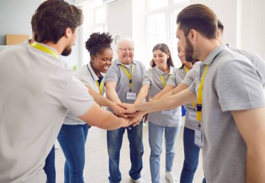 Gönüllülerden oluşan bir ekip topluluk hayır kurumunda çalışırken kollarını bir yığın yığının içine koyuyorlar. İnsanlar yemek bankasında gönüllü çalışıyor. Kötü kavram için insani yardım ve sosyal yardım.