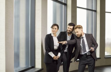 Erkek emlakçı sunar, emlakçı dairenin penceresini gösterir, satar, kira veya satış için mülk alır, müşterilerle anlaşma yapar, sergi, ipotek veya kira, danışmanlık yapar.