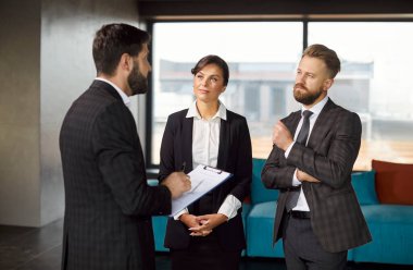 İş adamları konuşuyor, tartışıyorlar, modern ofis salonunda duruyorlar, motivasyonlu takım, ipotek veya kira belgeleri, proje detaylarını sunan, tartışan iş adamları, araştırma sonuçları