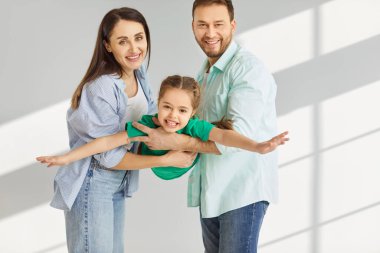Mutlu aile, neşeli gülümseyen ebeveynler sevgili küçük kızı ellerinde tutuyorlar, çocuk evde gülüyor, sevinç çığlıkları atıyor, aile eğlencesine eğlencesine eğleniyor, uçak eğlencesine oynuyor, eğlenceli bir gün.