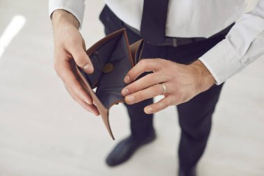 Boş deri cüzdan tutan işsiz bir adamın açık el çantası. Kendini fakir hissediyor. Parasız stresli, maddi sorunları olan, parasızlık çeken, iflas krizinden muzdarip. 