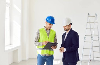 İnşaatçı ve bir işadamı, bir ev veya ofis inşaatı veya tadilatı yapmayı ve bir tahmini gözden geçirmeyi planlıyor. Projenin başarılı olması için mimarla konuşma ve işbirliği.