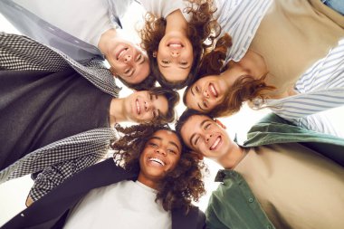 Bir grup öğrenci birlikte eğleniyor. Altı tane çok kültürlü yakışıklı genç insan toplanmış, sarılıyor ve kameraya gülümsüyor. Sınıf arkadaşları birlikte zaman geçirir. Düşük açı.