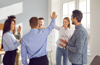 İş adamları bir beşlik çakıyor ve ofis toplantısında alkışlıyorlar. Meslektaşlar, iş ortakları başarıyı kutluyor, iş sonuçları. İyi iş, iş başarısı, motivasyon