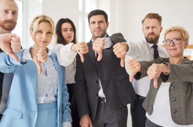 Ofiste birlikte duran bir grup profesyonel, hepsi de baş parmak işareti gösteriyor. Genç iş adamları anlaşmazlık, memnuniyetsizlik ve hoşnutsuzluğu dile getiriyorlar, öneri veya fikri açıkça reddediyorlar.