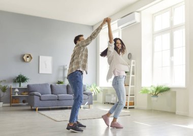 Mutlu evli çift evde dans ediyor, eğleniyor ve eğleniyorlar. Sevgi, sevgi ve bağlılık, bu mutlu anın tadını çıkararak ilişkilerini güçlendiriyorlar..