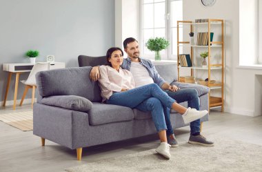 Evdeki kanepede oturan mutlu ve rahat aile çifti. Gülümseyen karı koca televizyon seyrediyor, hafta sonu keyfine bakıyor. Aile yaşam tarzı, eğlence konsepti