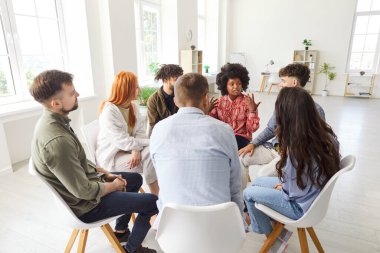 Bir grup iş adamı takım toplantısı ya da antrenman için toplanır, ofiste bir daire içinde otururlar. Takım çalışmasına ve sohbete girişerek, profesyonel büyüme ve işbirliğine odaklanırlar..