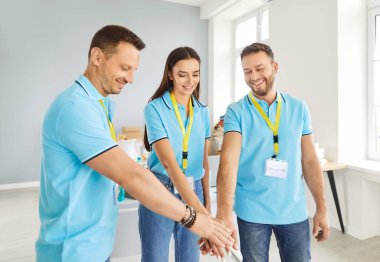 Sıraya dizilip toplum hayır kurumunda çalışan genç ve mutlu gönüllülerin portresi. Gönüllü ve insani yardım kavramı.