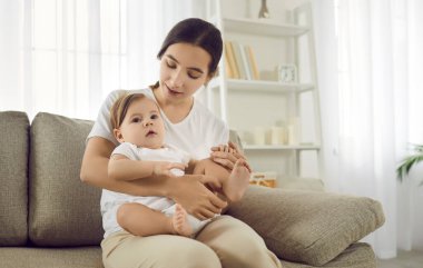 Sevgi dolu beyaz bir anne kanepeye oturur ve bebek bebekle oynar. Doğum keyfine varır. Önemseyen mutlu anne, yeni doğmuş çocukla evde rahatça konuşabiliyor. İyi bir lV tedavisi, doğurganlık. Annelik kavramı.