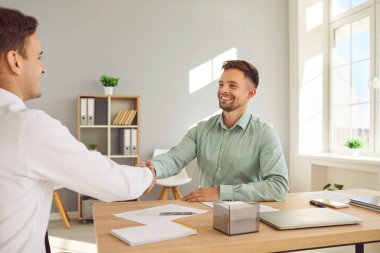 İş adamları iş yerinde masanın üzerinde el sıkışıyor toplantıyı bitiriyor, başarıyı ya da başarıyı kutluyor, iyi bir anlaşma yapıyor, kontrat imzalıyor ya da yeni bir çalışanı selamlıyor..