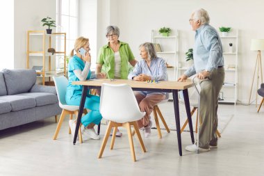 Yaşlı yaşlı bir grup ve ilgili bir hemşire telefon görüşmesi yapıyor, yaşlılara bakım evi sakinlerine yardım ediyor, destekli yaşam veren yaşlı yetişkinler, hastaları ziyaret eden kadın doktorlar. 