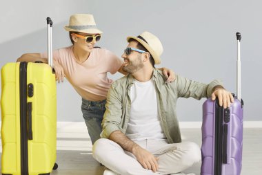 Erkek arkadaşlarıyla balayını deniz kenarında geçirip yaz turuna hazırlanırken, şapka ve güneş gözlüğü takıp bavullarla poz verirken çekilen kapalı çekimler. Kadın ve erkek tatil planlıyor