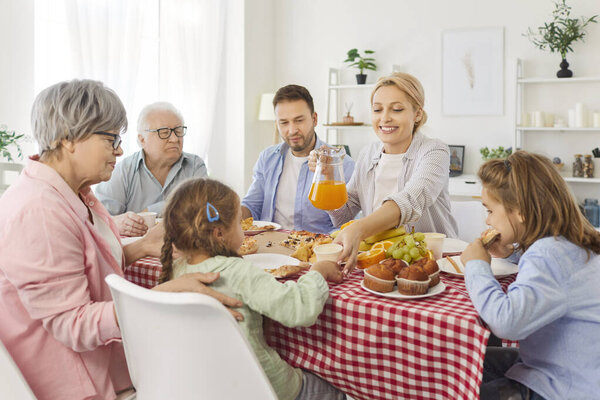 Happy big family people common meal three generation gathering, grown up adult children, senior grandparents, kids at home holiday together, homemade food, talking, laughing, enjoying leisure time 
