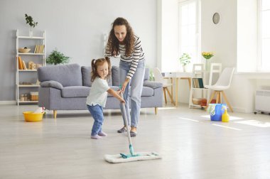 Şefkatli anne ve küçük kızı evde temizlik işleriyle meşgul. Anne, temizlik için paspas kullanırken kızına rehberlik ediyor. Ev işlerinde takım çalışması ve eğlence gösteriyor..