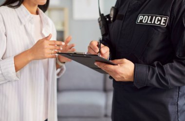 Olay yerinde rapor yazan bir erkek polis ya da dedektifin yakın çekimi. Kolluk kuvvetlerinin suçu araştırmaya, kamu güvenliğini sağlamaya ve ayrıntılı belgelere olan bağlılığı.