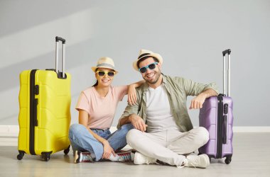 Yeni evli çiftin bavulları toplanmış, plajda tekerlekli bavulları var. Şapka takıyorlar, güneş gözlükleri takıyorlar. Turizmin, yolculuğun, yolculuğun, yolculuğun, yolculuğun, yeni evli tatilin, balayı planının keyfini çıkarmaya hazırlar.
