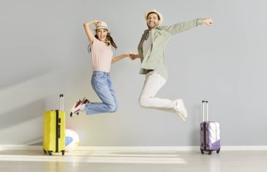 Neşeli atlayışlar, yeni evli çift bavullarını topladılar, yaz plajında tekerlek valizleri, turizmin, yolculuğun, yolculuğun, yolculuğun, yeni evli tatilin, balayı planlama eğlencesinin tadını çıkarmaya hazırlar.