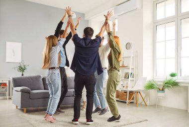 Heyecanlı bir grup mutlu genç öğrenci ya da meslektaşlar evde birlikte takılırken eğleniyorlar. Erkekler ve kadınlar el kaldırarak bir çember oluşturup toplanmanın ve eğlencenin tadını çıkarıyorlar..