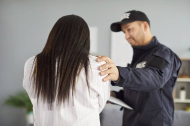 Polis, üniformalı polis memuru yardım etmeye çalışıyor, ev istismarı, suç, yaralı kadın yüzünü utanç, keder, üzüntü ile kapatıyor, tavsiye ve güvence sunuyor.