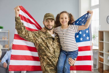 Vatansever aile fotoğrafı. Evde dikilirken elinde Amerikan bayrağı tutan bir baba ve kızının portresi. Küçük kız, Amerikan ordusundan babasıyla tanıştığı için mutlu..