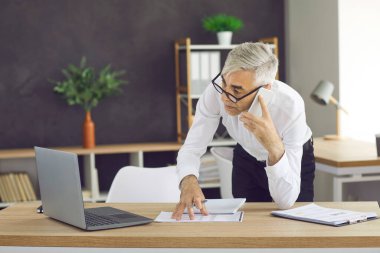 Modern bir ofiste cep telefonuyla konuşan bir iş adamı. Ofiste bir adam dizüstü bilgisayara bakar ve cep telefonuyla konuşur. Beyaz gömlekli ve gözlüklü son sınıf öğrencisi geldi..