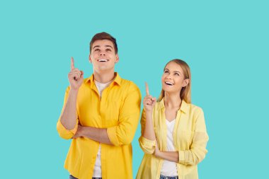 Vay canına, şuraya bak. Neşeli genç çift, açık mavi arka planda fotokopi alanını gösteren yeni ürünleri sunuyor. Gençlik tişörtleri, tişörtler ve kotlar reklam ya da tavsiye ediyor.