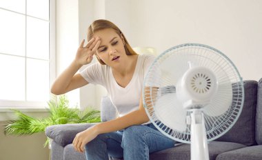 Kadın yaz sıcağında bunalmaktan yoruldu. Genç bir kız aşırı ısınmış bir dairede oturuyor, terli alnını siliyor ve yüzüne çarpan elektrikli vantilatörden temiz hava almaya çalışıyor. Sıcak yaz konsepti