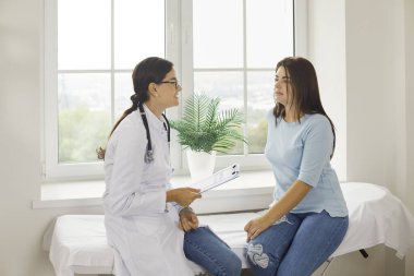 Genç bir kadın, hastanede muayene sırasında kadın doktoruyla konuşur. Hastanın dediğine göre sağlığından endişe ediyormuş. Doktor muayenehanesinin penceresinin yanındaki kanepede oturuyormuş..