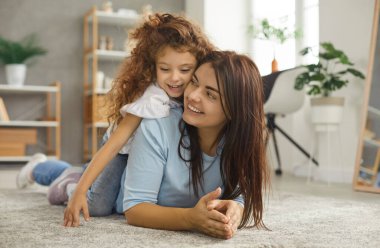 Gülümseyen beyaz bir anne heyecanlı ergen kızıyla evde oyun oynuyor. Mutlu anne ya da dadı eğleniyor rahatlayın küçük 7 'lerin kızıyla eğlenin. Ebeveynlik kavramı.