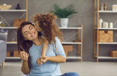 Küçük Kafkas 7 'li kızları seven kız çocuğu öpücükler evde birlikte oynayan genç anneye sevgi göstergesi. Minnettar küçük kızım anne ve babasına şükranlarını sunuyor. Annelik, aile bağları..