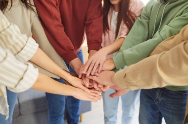 Gündelik giysiler içinde genç arkadaşlara ya da bir grup öğrenciye yakın çekim yapmak için toplanmış ve kollarını kapalı bir yere koymuşlardı. Arkadaşlık, birlik ve takım çalışması kavramı.