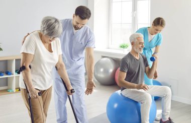 Rehabilitasyon merkezindeki eğitmenler yaşlı bir çiftin iyileşmesine yardım ediyor. Yaşlılara tıbbi bakım yapılıyor. Koltuk değneği ve fizyoterapi kullanarak aktif rehabilitasyon kavramı