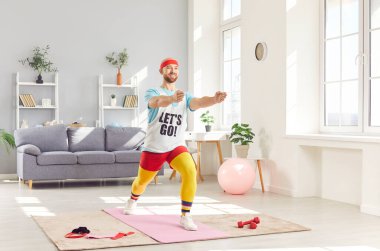 Egzantrik spor giyimli komik adam evde aerobik yapıyor. Eski tarz giyinmiş bir sporcu. Sakallı adam spor yapıyor. Konsept sağlık, fiziksel egzersiz, erkek sporu, aerobik retro