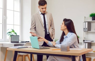 İş adamları, bilgisayardaki çeşitli ortaklar, modern ofis ortamında çalışan erkek ve kadın iş arkadaşları. İşadamı genç iş kadınına sorar, birlikte çalışır projeyi tartışır, düzeltir
