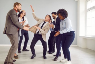 İş arkadaşları arasında dans eden adam başarılı bir olayı kutluyor. Takım, takım çalışmasını, heyecanı ve güçlü bir başarı duygusunu vurgulayan bir kurumsal partiye katılıyor..