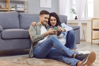 Aile çifti evde birlikte vakit geçirmekten, yerde oturup konuşmaktan hoşlanır. Online eğlence için telefon kullanıyorlar, birlikte zaman geçiriyorlar, internete bağlanıyorlar..